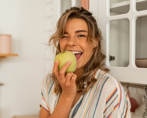 Cure TMJ Naturally - Woman Eating an Apple